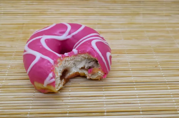 Bambu arka planında pembe bir çörek.