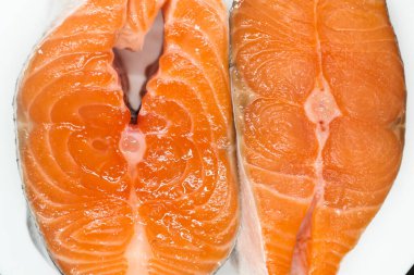 Beyaz tabakta iki sulu somon bifteği.