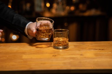  Barmen viski bardağını dolduruyor. Lokantadaki arkadaşça bir partide viskiyi kutluyor.