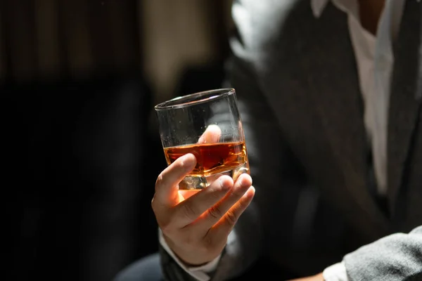 ビジネスマンが酒の貯蔵室でウィスキーを飲む ロイヤリティフリーのストック写真