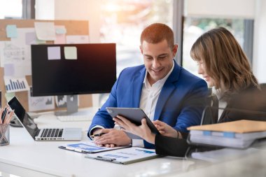 Asyalı iş hediyeleri beyaz tahtadaki grafiği açıklıyor. Danışmanlık, tartışma, bilgi alışverişi..