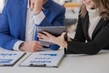 Asyalı iş hediyeleri beyaz tahtadaki grafiği açıklıyor. Danışmanlık, tartışma, bilgi alışverişi..