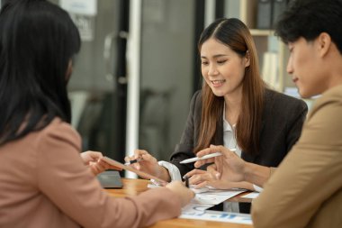 Asyalı iş hediyeleri beyaz tahtadaki grafiği açıklıyor. Danışmanlık, tartışma, bilgi alışverişi..