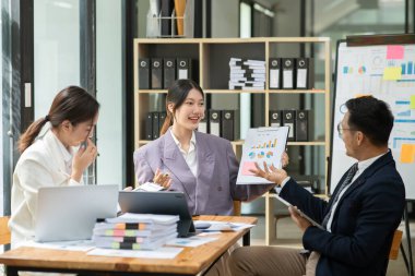 Asyalı iş hediyeleri beyaz tahtadaki grafiği açıklıyor. Danışmanlık, tartışma, bilgi alışverişi..