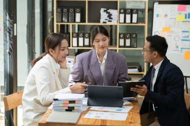 Asyalı iş hediyeleri beyaz tahtadaki grafiği açıklıyor. Danışmanlık, tartışma, bilgi alışverişi..