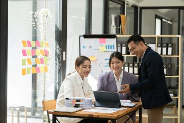 Asyalı iş hediyeleri beyaz tahtadaki grafiği açıklıyor. Danışmanlık, tartışma, bilgi alışverişi..