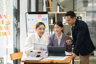 Asyalı iş hediyeleri beyaz tahtadaki grafiği açıklıyor. Danışmanlık, tartışma, bilgi alışverişi..