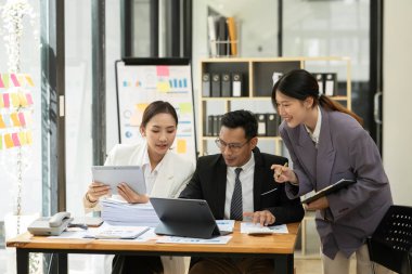 Asyalı iş hediyeleri beyaz tahtadaki grafiği açıklıyor. Danışmanlık, tartışma, bilgi alışverişi..