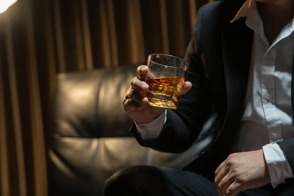 ビジネスマンが酒の貯蔵室でウィスキーを飲む ストック写真