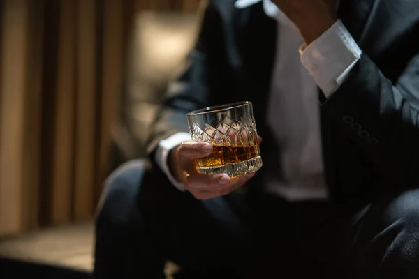 ビジネスマンが酒の貯蔵室でウィスキーを飲む ロイヤリティフリーのストック写真