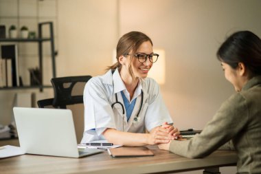 Kadın doktor hastanedeki klinikte bir kadın hemşireye danışmanlık yapıyor.