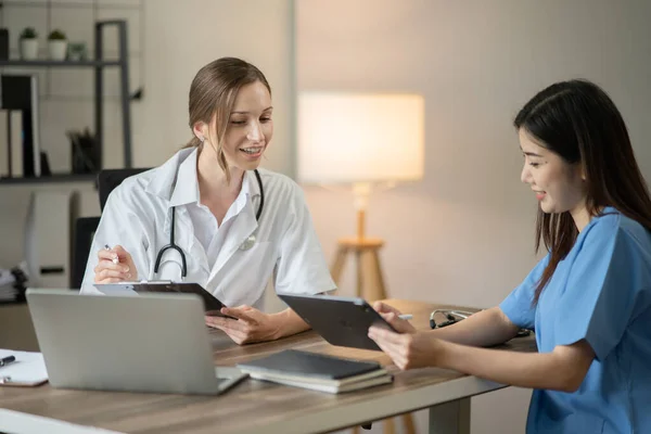 female doctor consulting with a female nurse at the clinic at the hospital