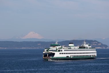 Arka planda dağlar olan büyük gemi mavi okyanusta yelken açar. Pasifik Kuzeybatı Washington Eyaleti Puget Sound