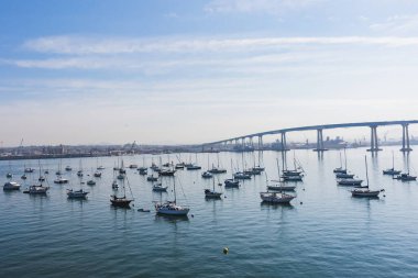 San Diego Körfezi üzerindeki Coronado Köprüsü 'nde yelkenli tekneler, gökyüzü, gemiler, ulaşım, su ve rıhtım. Kaliforniya.