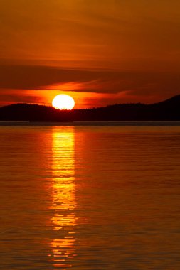 Gün batımında görkemli dağlar sakin denize altın saati yansıtır. Puget Sound Pacific Kuzeybatı Washington Eyaleti