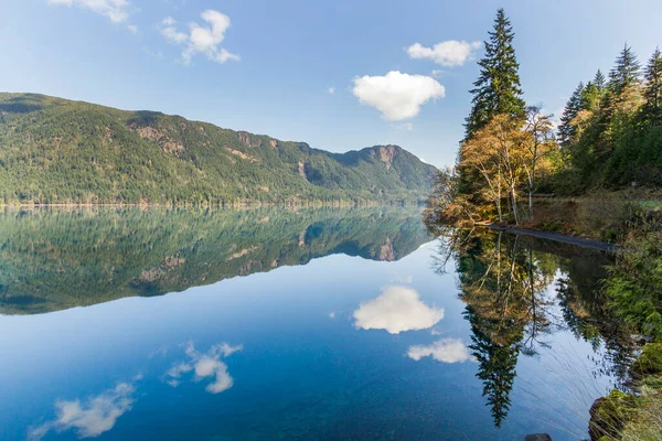 Untouched wilderness with mountains, forest, lake, and serene reflection in water. Lake Crescent Olympic Peninsula Washington State