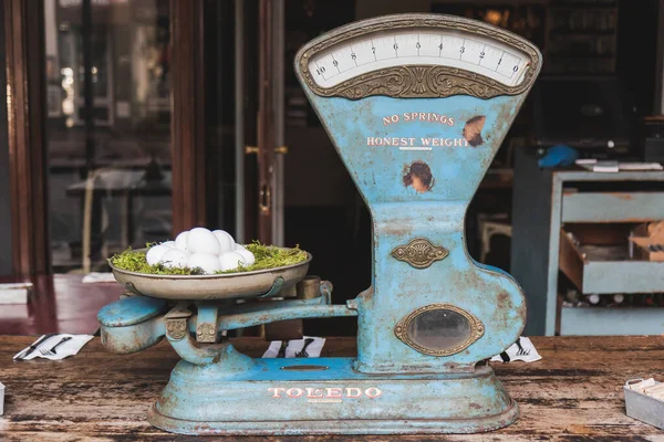 stock image Horizontal photo focused on Nostalgic creativity: old weighing scale and solitary white egg in a wooden table with knife and fork under a tissue.