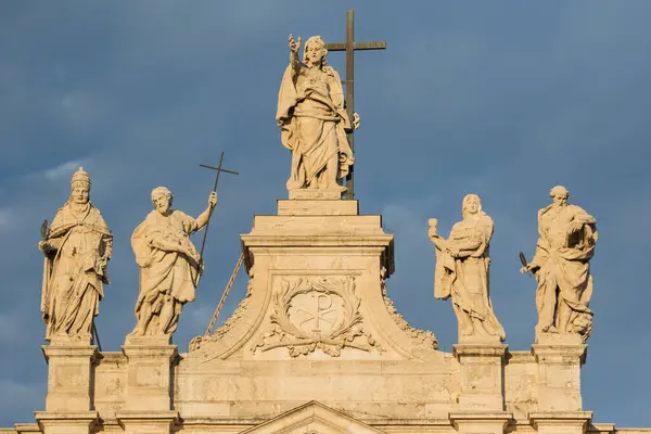 St. John Lateran Bazilikası 'nın tepesindeki Sunlit heykellerinin yatay fotoğrafı. Antik, tarihi mimari, dini anıtlar, sanatsal heykeller. Zengin tarihin büyüleyici hedefi.