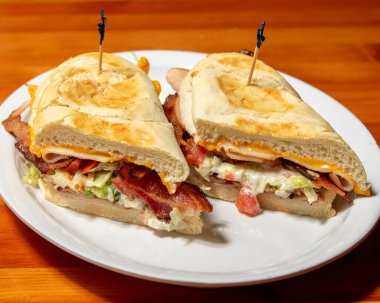 Beyaz tabakta iki lezzetli ve lezzetli pastırmalı sandviçin yüksek açılı görüntüsü.