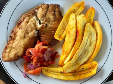 Yakın plan bir fotoğraf et, sebze ve kızarmış muz ile sağlıklı bir yemek, muz, muz ve meyve beyaz tabak üzerinde.