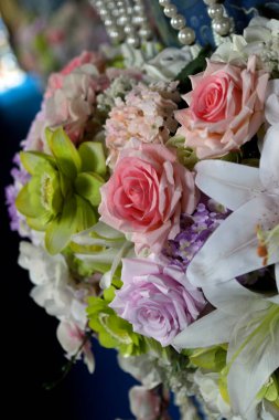 Pembe, mor, yeşil ve beyaz çiçeklerin dikey fotoğrafı sergilenen güzellik ve zarafeti sergiliyor.