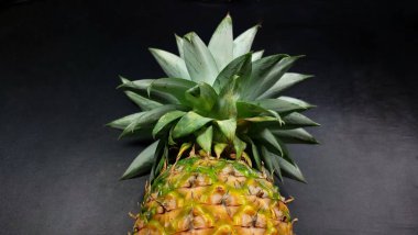 Siyah taşlı arka planda olgun bir ananas..