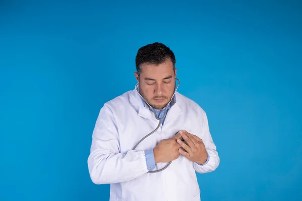 Médico Verifica Coração Com Estetoscópio Num Fundo Azul Isolado Conceito — Fotografia de Stock