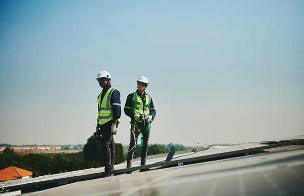 Två Manliga Solinstallationstekniker Skyddsdräkt Står Taket Till Höghus Stockbild