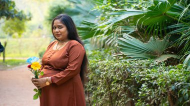 Parktaki genç hamile Hintli kadın, Hamilelik, annelik konsepti