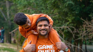 Neşeli Hintli baba ve oğul parkta eğleniyor. Babalık kavramı.