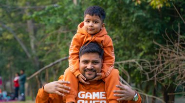 Neşeli Hintli baba ve oğul parkta eğleniyor. Babalık kavramı.