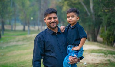 Neşeli Hintli baba ve oğul parkta eğleniyor. Babalık kavramı.