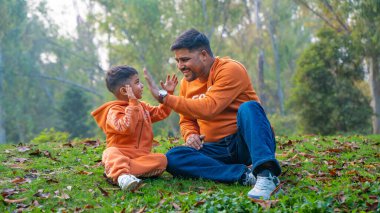 Neşeli Hintli baba ve oğul parkta eğleniyor. Babalık kavramı.
