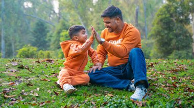 Neşeli Hintli baba ve oğul parkta eğleniyor. Babalık kavramı.