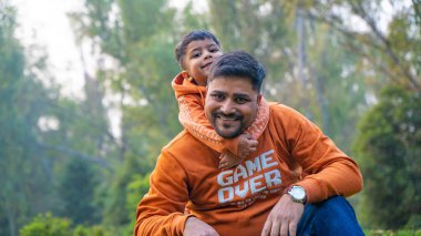 Neşeli Hintli baba ve oğul parkta eğleniyor. Babalık kavramı.