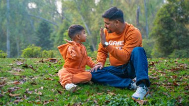 Neşeli Hintli baba ve oğul parkta eğleniyor. Babalık kavramı.