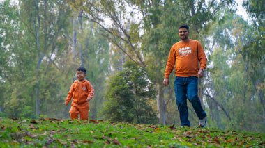 Neşeli Hintli baba ve oğul parkta eğleniyor. Babalık kavramı.