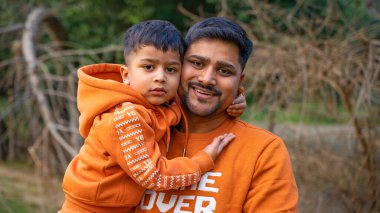 Neşeli Hintli baba ve oğul parkta eğleniyor. Babalık kavramı.