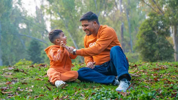 Neşeli Hintli baba ve oğul parkta eğleniyor. Babalık kavramı.