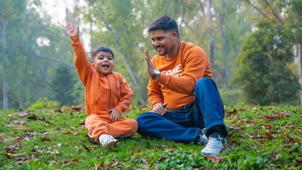 Neşeli Hintli baba ve oğul parkta eğleniyor. Babalık kavramı.