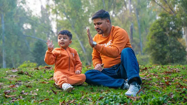 Neşeli Hintli baba ve oğul parkta eğleniyor. Babalık kavramı.