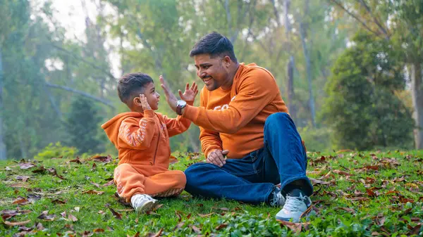 Neşeli Hintli baba ve oğul parkta eğleniyor. Babalık kavramı.