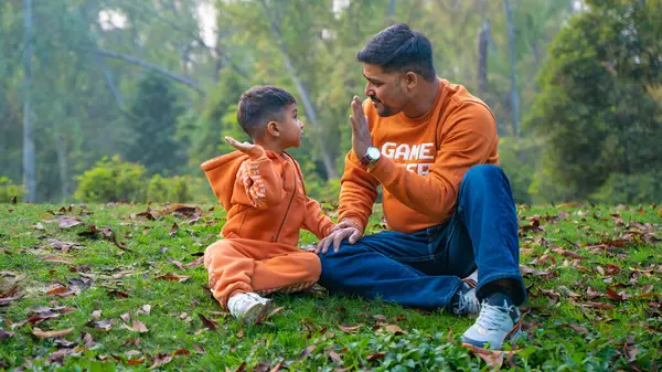 Neşeli Hintli baba ve oğul parkta eğleniyor. Babalık kavramı.