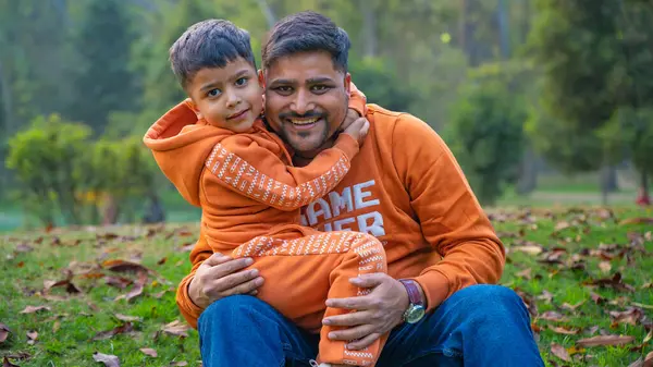 Neşeli Hintli baba ve oğul parkta eğleniyor. Babalık kavramı.