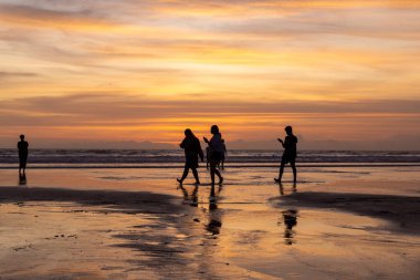 İnsanlar gün batımında Seminyak sahilinde, Bali Adası, Endonezya