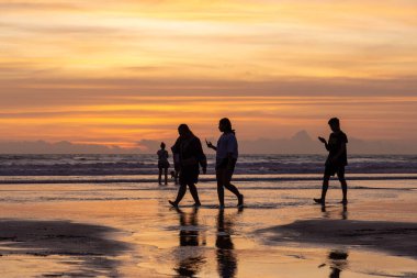 İnsanlar gün batımında Seminyak sahilinde, Bali Adası, Endonezya