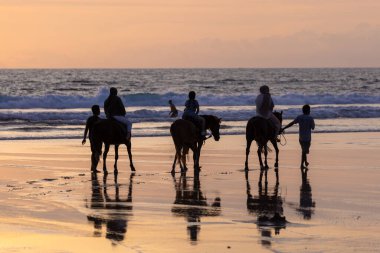 Gün batımında Seminyak sahilinde at binicileri, Bali Adası, Endonezya