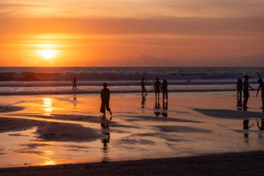 İnsanlar gün batımında Seminyak sahilinde, Bali Adası, Endonezya