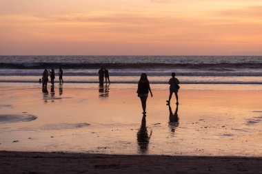 İnsanlar gün batımında Seminyak sahilinde, Bali Adası, Endonezya