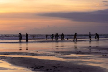 İnsanlar gün batımında Seminyak sahilinde, Bali Adası, Endonezya